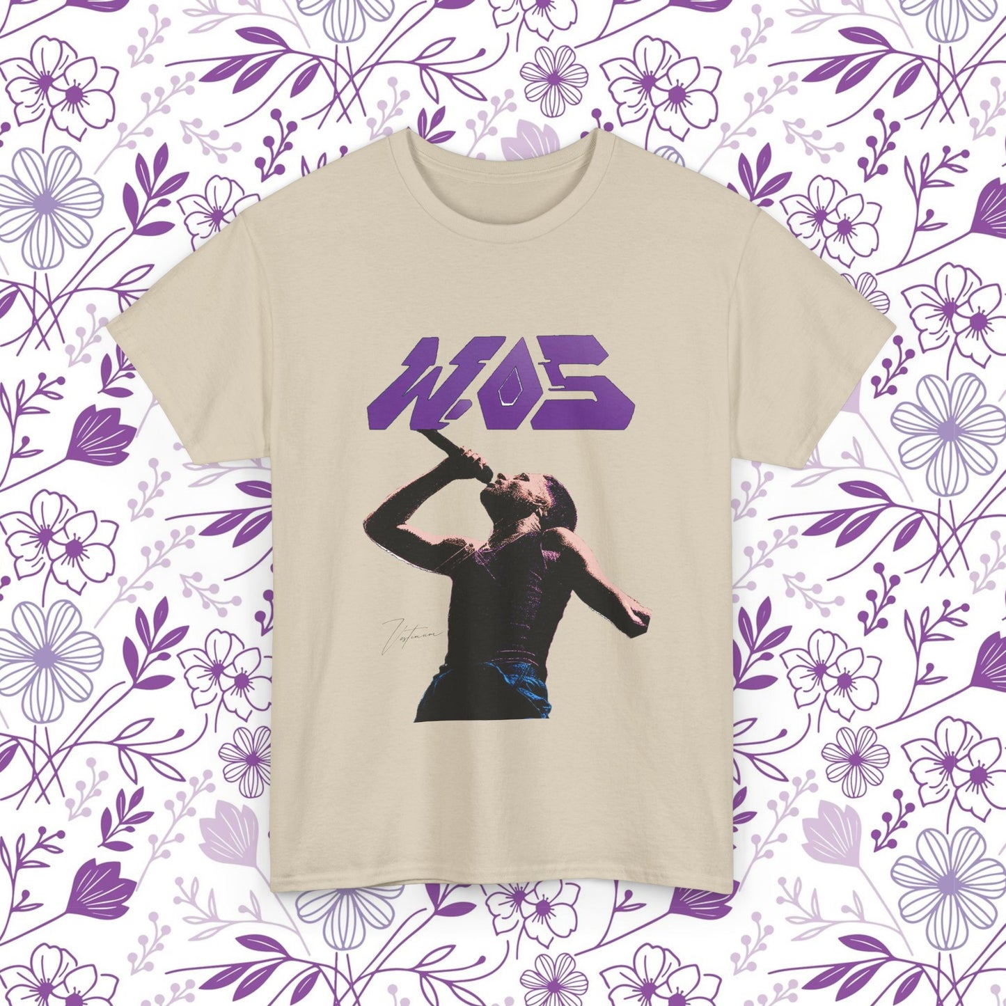 Camiseta WOS con retrato pop art y logo en color púrpura sobre fondo floral, estilo urbano y moderno.